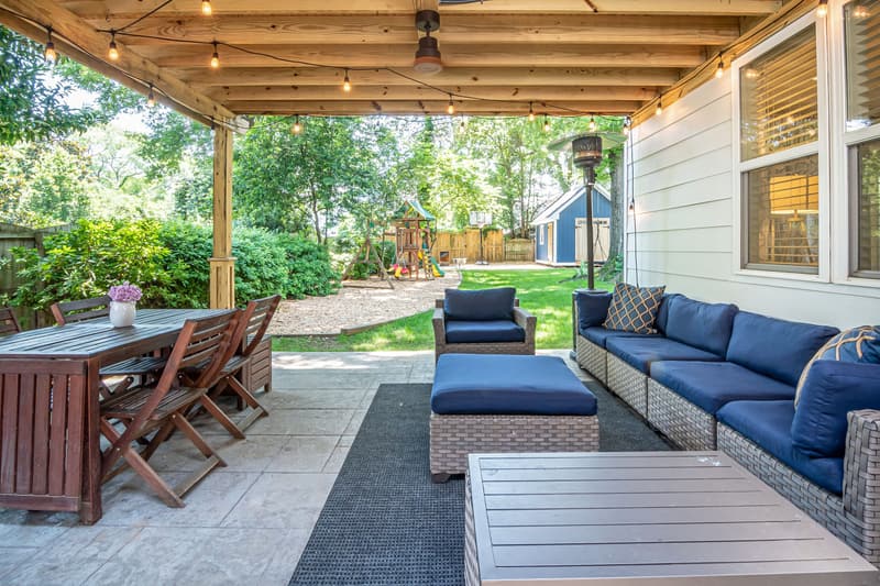 Attached patio cover with a fan and string lights