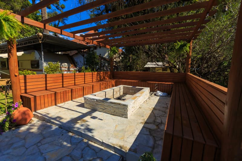 Timber pergola over a stone fire pit