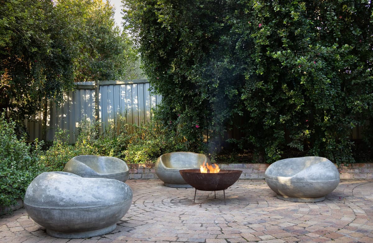 Fire bowl and sculpted seats on a round paver patio
